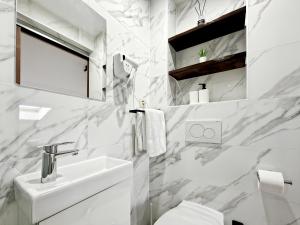 a white bathroom with a sink and a toilet at Hatton - 650m do plaży ! in Grzybowo +112 photos