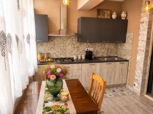 a kitchen with a table with a vase of flowers on it at Flavia's House in Gaggi +16 photos