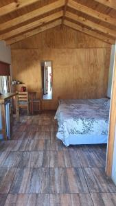 a bedroom with a bed and a wooden ceiling at Alojamiento Parcela El Aromo in Paine