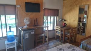 a living room with a room with a refrigerator and a table at Alojamiento Parcela El Aromo in Paine +8 photos