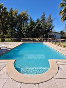 a swimming pool with blue water in a yard at Alojamiento Parcela El Aromo in Paine