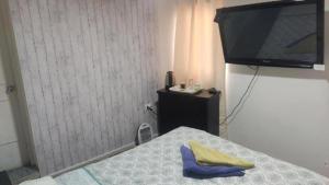a bedroom with a bed and a flat screen tv at Alojamientos Quintamar Viña in Viña del Mar