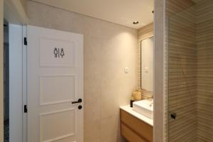 a bathroom with a white door and a sink at Tinico's Guest Rooms in Nazaré