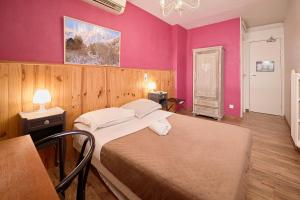 a bedroom with a large bed with pink walls at La Caravelle in Riom +149 photos