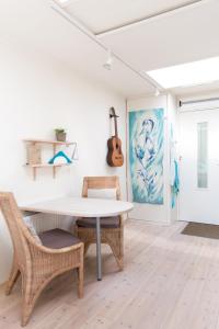 a dining room with a table and chairs and a guitar at BBBoekelo appartement in Boekelo