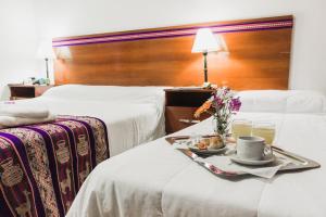 a hotel room with two beds with a tray of food at Inti Masi in Salta