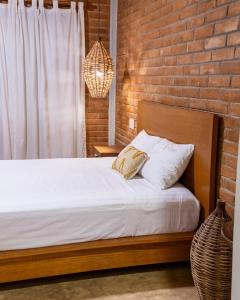 a bedroom with a bed and a brick wall at Santuario San Agustín in Bajo de Arenal