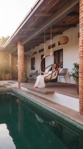 a hammock hanging from a porch next to a swimming pool at Santuario San Agustín in Bajo de Arenal +14 photos