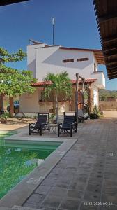a pool with two benches next to a building at Santuario San Agustín in Bajo de Arenal