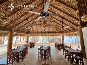a restaurant with tables and chairs and a ceiling fan at Santuario San Agustín in Bajo de Arenal