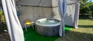 a hot tub in a tent with a chair at Apartmani Ćosić in Kuršumlija
