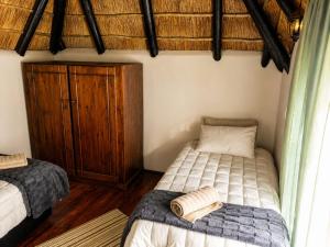 a bedroom with two beds and a wooden cabinet at Les Clés de Parys in Parys