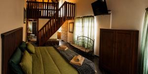 a bedroom with a green bed and a staircase at Les Clés de Parys in Parys