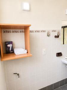 a bathroom with a sink and a shelf with towels at Miniloft Centrico in El Calafate
