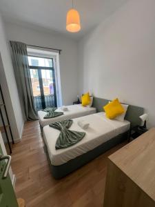 a room with two beds and a window at 7 Requinte HOSTel in Lisbon