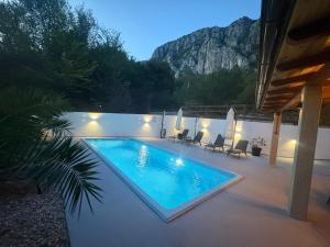 a swimming pool on a patio with a mountain in the background at Kuca za odmor Adriatica in Antovo