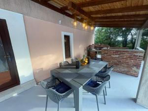 a patio with a table and chairs and a brick wall at Kuca za odmor Adriatica in Antovo