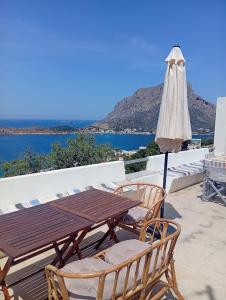 a wooden table and two chairs and an umbrella at Onar Myrties in Myrties