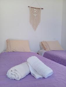 a white towel laying on top of a purple bed at Onar Myrties in Myrties