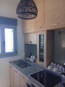 a kitchen with a sink and a pendant light at Onar Myrties in Myrties