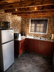 a kitchen with a white refrigerator and a window at Les Clés de Parys in Parys