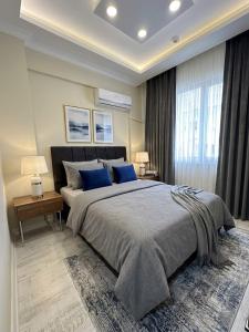 a bedroom with a large bed with blue pillows at Alas Garden City Apartment Fethiye in Fethiye +100 photos