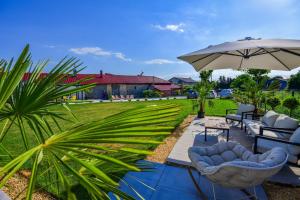 a patio with two chairs and an umbrella at Vila Manuela Techirghiol in Techirghiol
