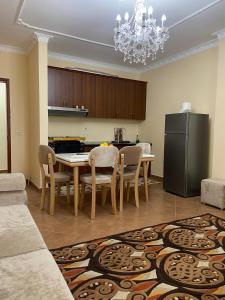 a kitchen with a table with chairs and a refrigerator at Lushnja Apartament in Lushnjë