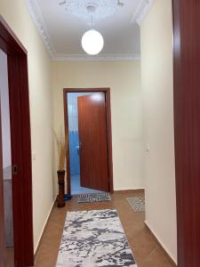 an empty hallway with a door and a rug at Lushnja Apartament in Lushnjë