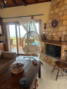 a living room with a chair and a fireplace at "Villa Othon-Leni" - Panoramic Sea View & Traditional Luxury in Paralia Demonias
