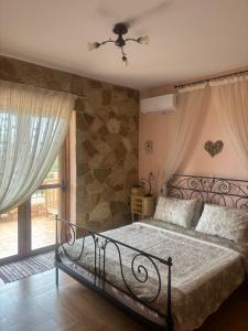 a bedroom with a bed and a stone wall at "Villa Othon-Leni" - Panoramic Sea View & Traditional Luxury in Paralia Demonias