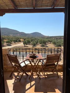 a table and two chairs on a balcony with a view at "Villa Othon-Leni" - Panoramic Sea View & Traditional Luxury in Paralia Demonias