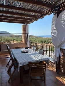 a table on the balcony of a house with a view at "Villa Othon-Leni" - Panoramic Sea View & Traditional Luxury in Paralia Demonias
