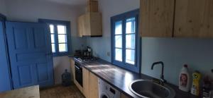 a kitchen with a sink and a blue door at iDILe in Râșca