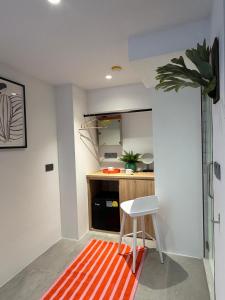 Eine Küche mit einem orange-weißen Teppich und einem Hocker in der Unterkunft Dreamloft Hotel in Singapur