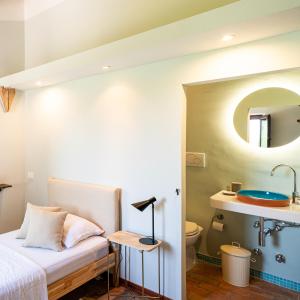 a bedroom with a bed and a bathroom with a sink at Rifugio Vita Luminosa in Montecarotto +29 photos