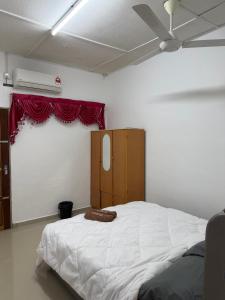 a bedroom with a large white bed and a window at Homestay Jerantut in Jerantut