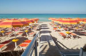 a bunch of chairs and umbrellas on a beach at Da zia Sofia in Torre Lapillo