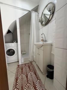 a bathroom with a sink and a washing machine at Leśny Domek in Piłka