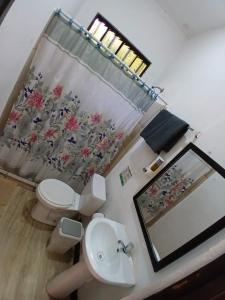 a bathroom with a toilet and a sink and a mirror at Hotel Jaco Lodge in Jacó +19 photos
