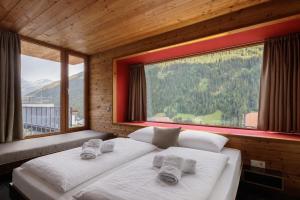 two beds in a room with two large windows at Aradira in Kappl