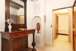 フィレンツェにあるCarmine Apartmentの鏡と花のテーブルが置かれた廊下