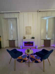 Ein Zimmer mit zwei Stühlen, einem Tisch und einem Kamin in der Unterkunft BrameL Suite in Lamezia Terme