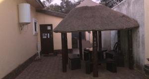 a small pavilion with a table and chairs in a building at Queen Room self contained in Lusaka