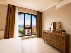 a bedroom with a large window and a dresser with a mirror at Pasha Residence in Trabzon