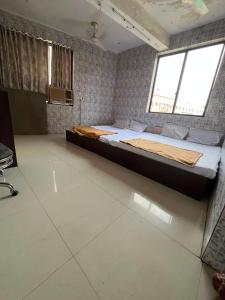 a large bed in a room with a large window at Hotel Novex in Rajkot