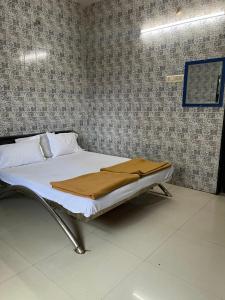 a hospital room with a bed with a blanket on it at Hotel Novex in Rajkot