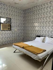 a bedroom with a bed with a blanket on it at Hotel Novex in Rajkot