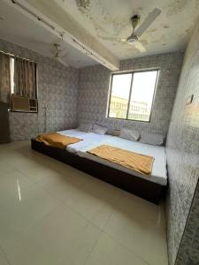 a large bed in a room with a window at Hotel Novex in Rajkot