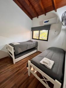 a bedroom with two bunk beds and a window at FlussHaus VGB in Villa General Belgrano